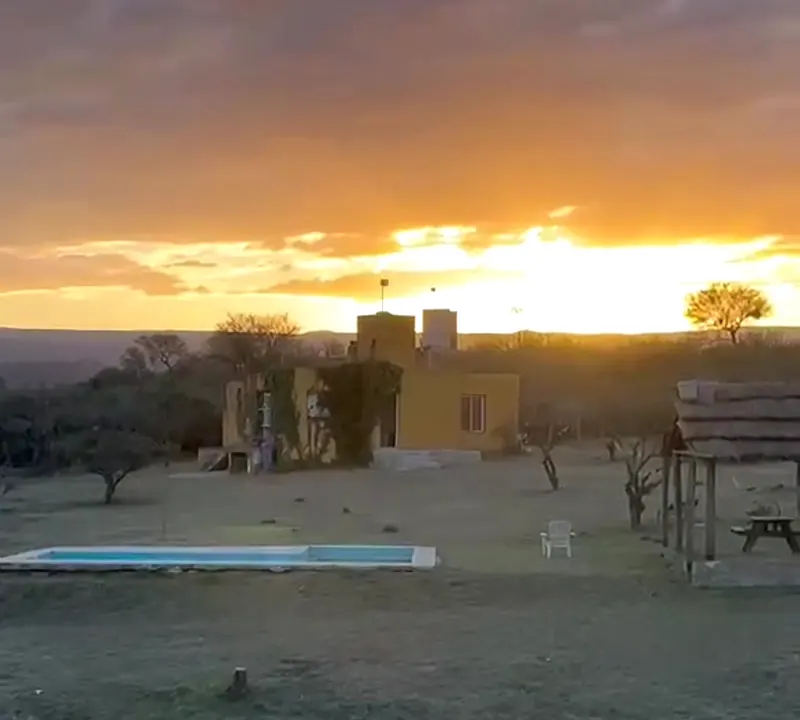 La casona y la pileta con el sol bajando